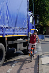 Ein LKW nimmt einer Radfahrerin beim Abbiegen die Vorfahrt