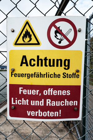 Ein Schild an einem Zaun warnt vor gefährlichen Stoffen.