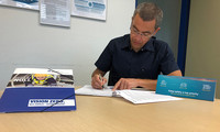 Foto: Man sieht Adam Drozny, Werkleiter SGL Composites Materials Germany GmbH, bei der Unterzeichnung des Kooperationsvertrags in Wackersdorf